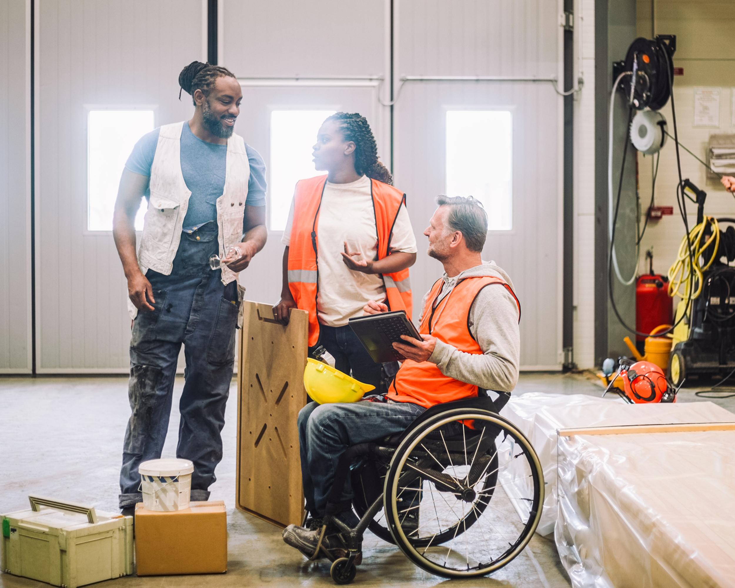 Arbetare på lager orange väst man i rullstol