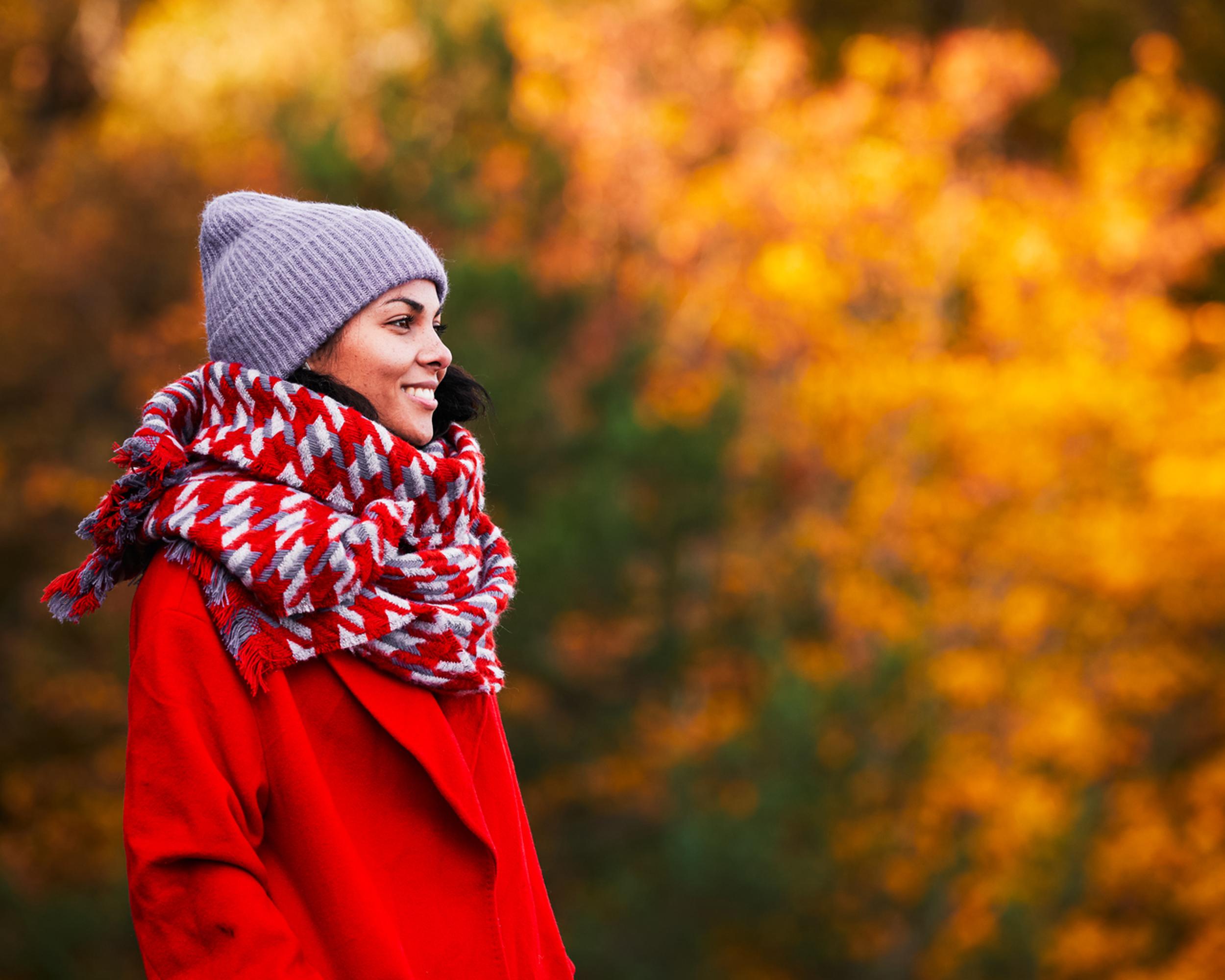 Glad kvinna bland höstlöv.