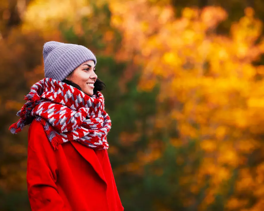 Glad kvinna bland höstlöv.