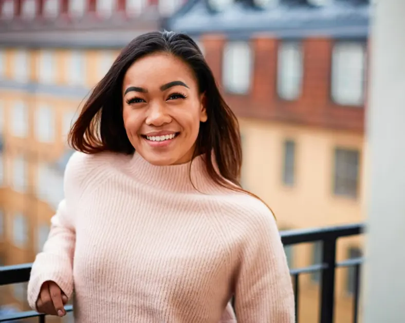 Glad kvinna på balkong.