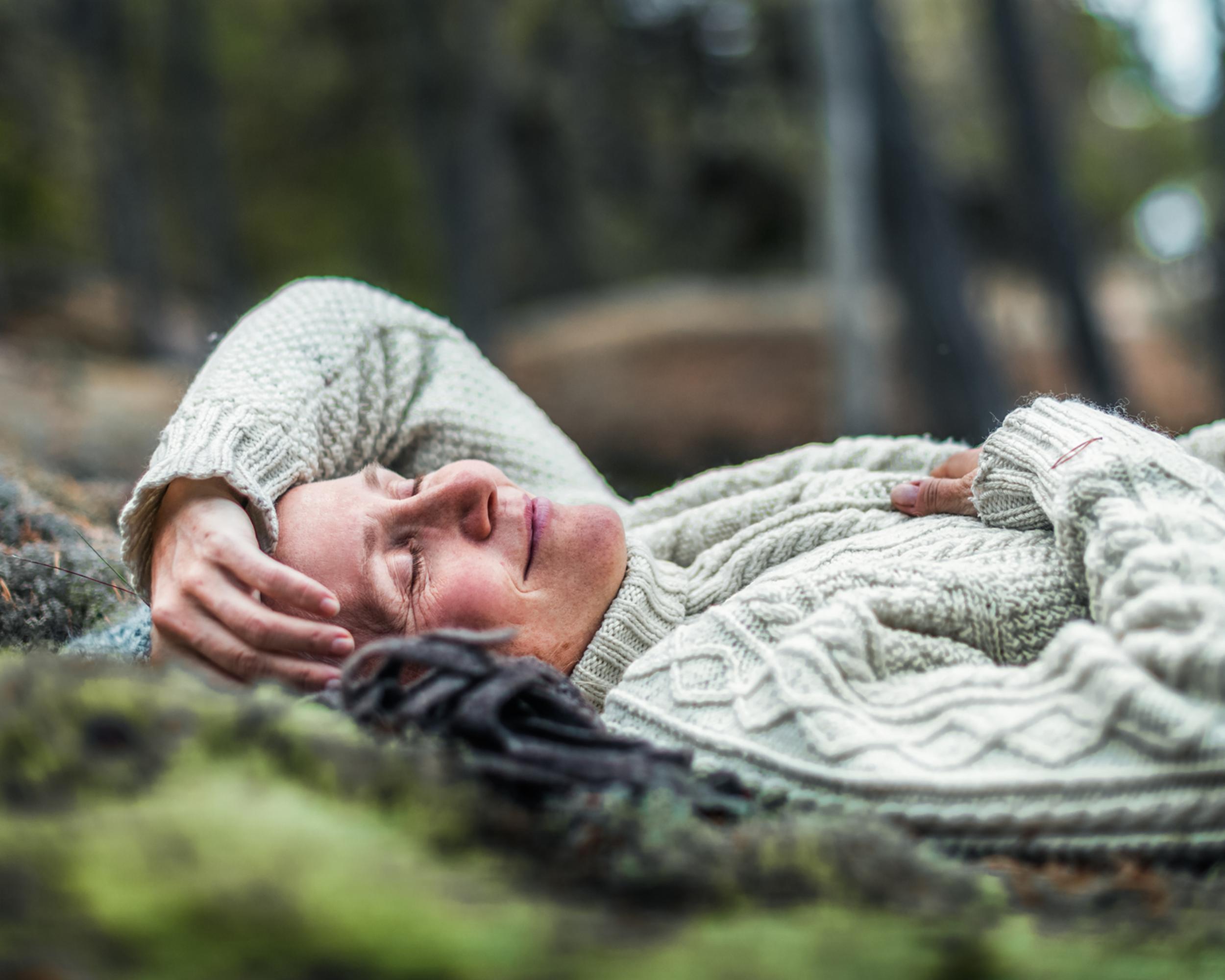 Kvinna ligger ner  skogen