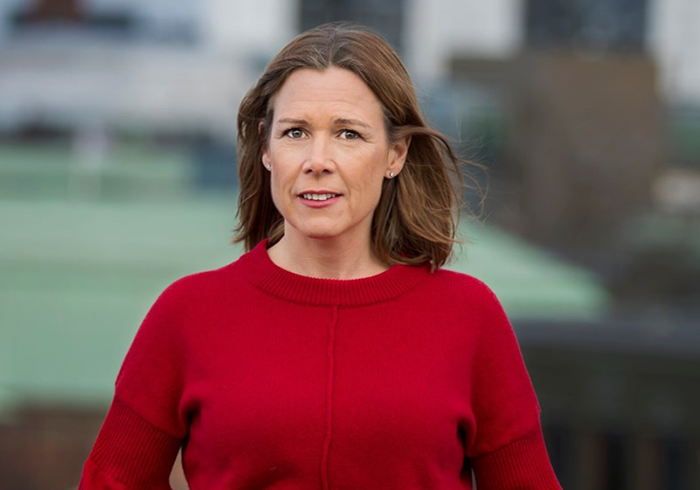 Kvinna i röd tröja utomhus med suddig bakgrund