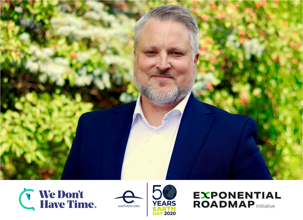 Person i kostym framför grönskande bakgrund, med logotyper för "We Don’t Have Time", "Earth Day 2020", och "Exponential Roadmap Initiative"